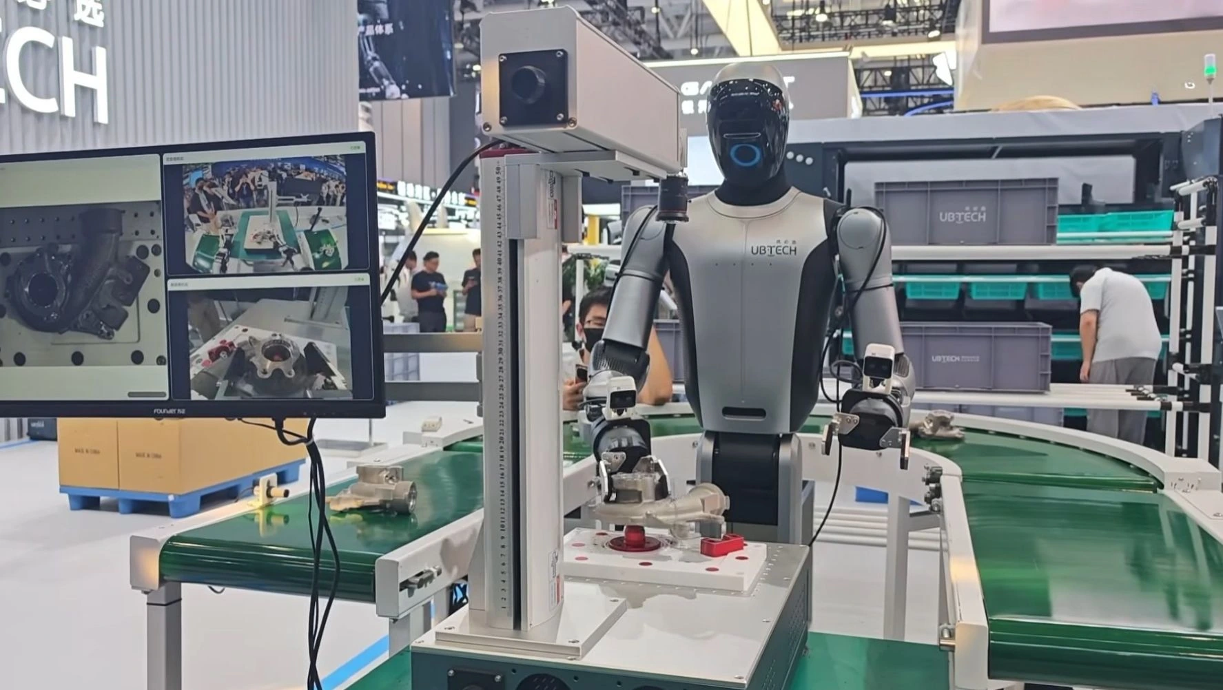 部品をつかむCruzr S2と、ロボットのカメラ映像を表示するモニター